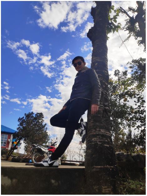 Nepali boy Wilson Shrestha posing in front of a tree at Murkut Bhangyang