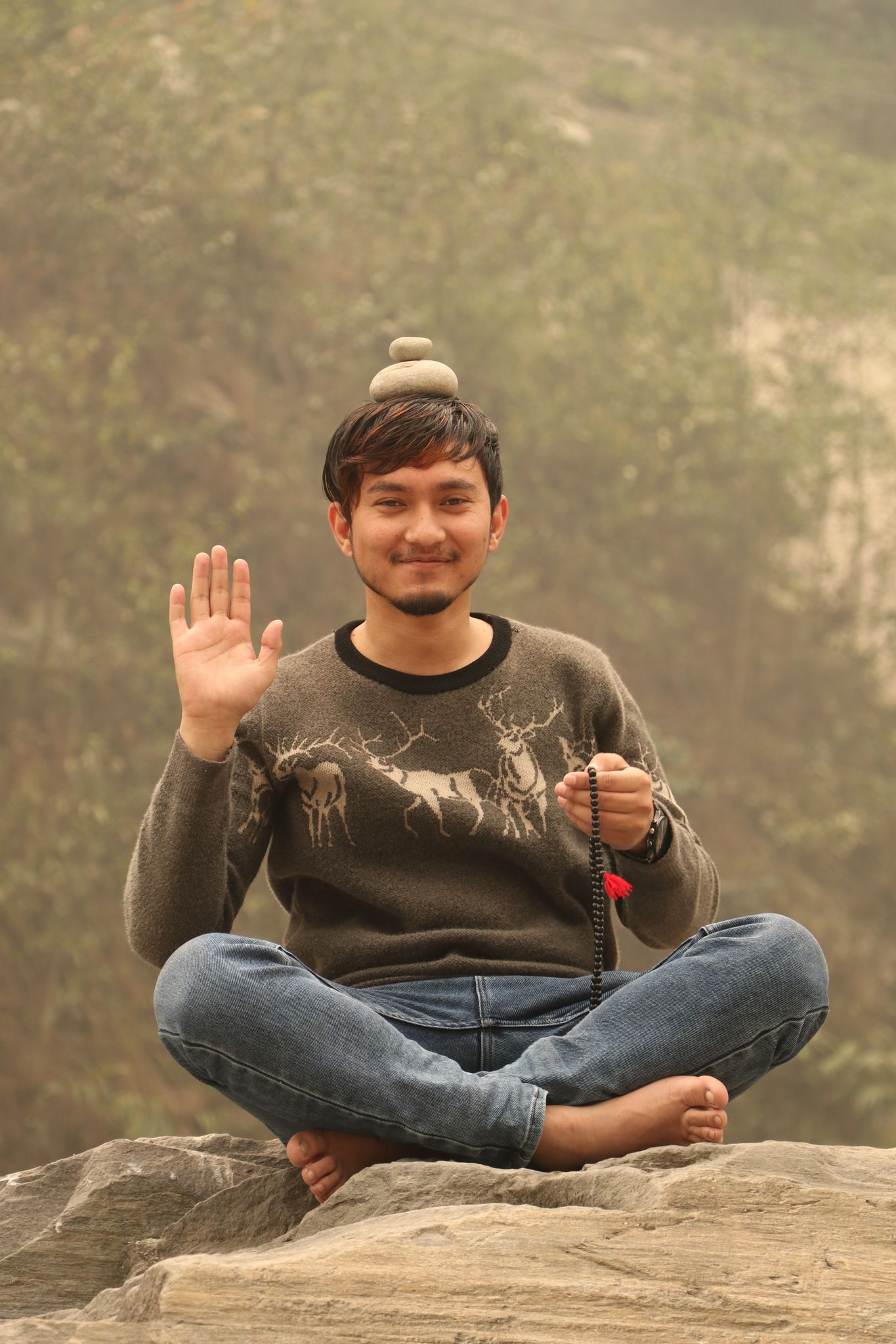 Wilson Shrestha posing with stones beside the Trisuli River